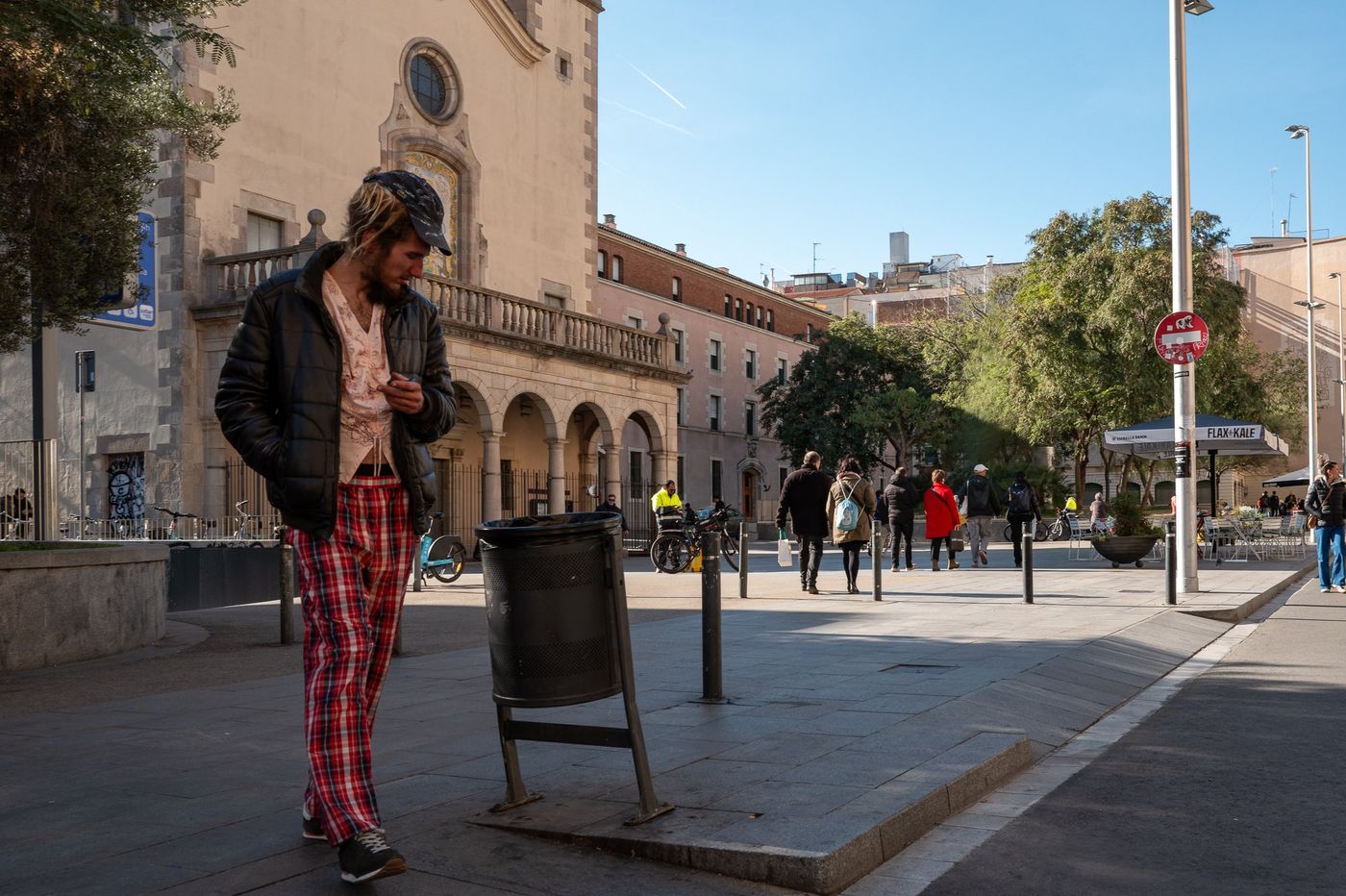 Passante en pantalon a motifs traversant une place, Barcelone