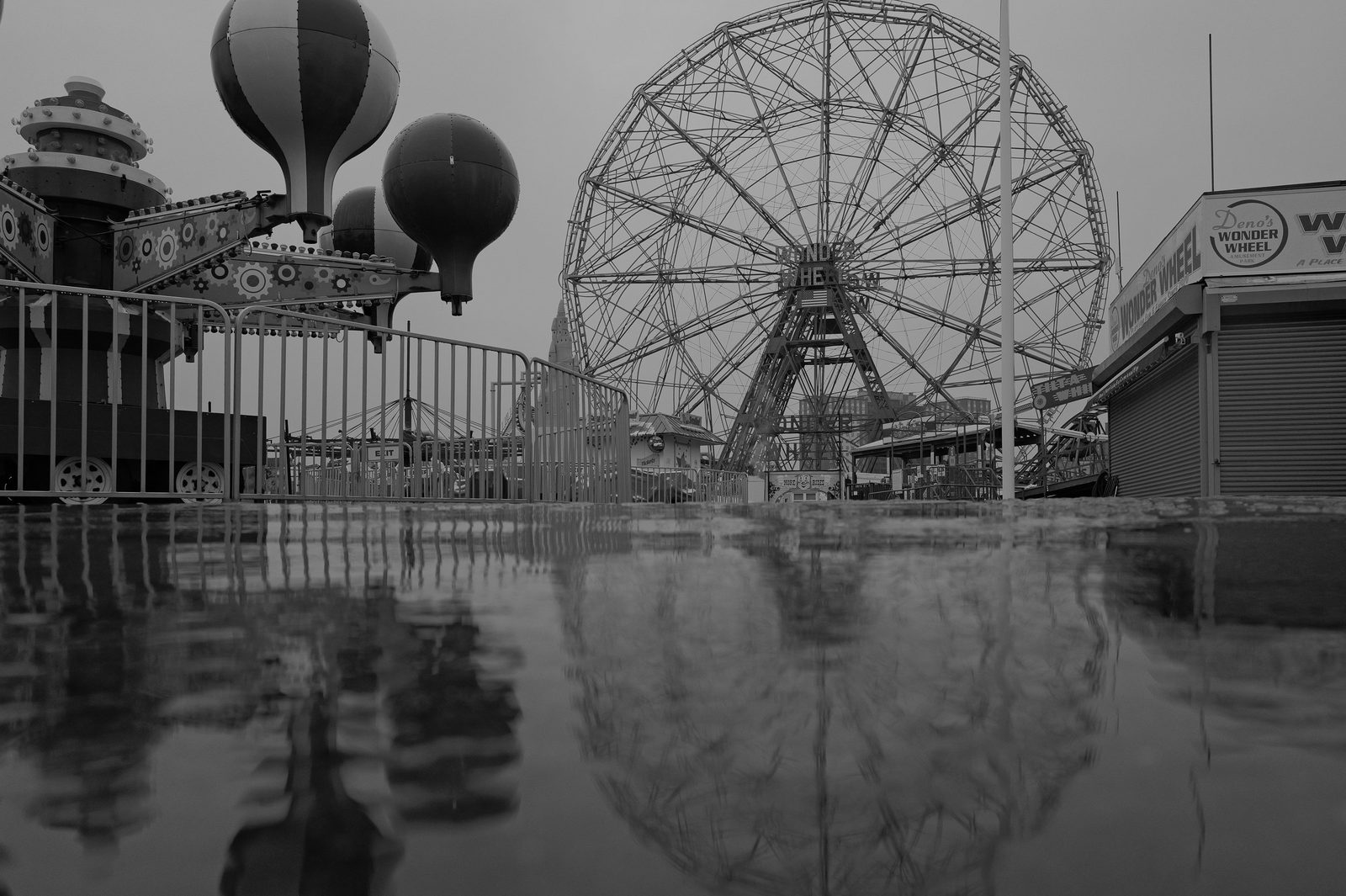 Grande roue et parc d'attractions se refletant sur le sol mouille, Coney Island