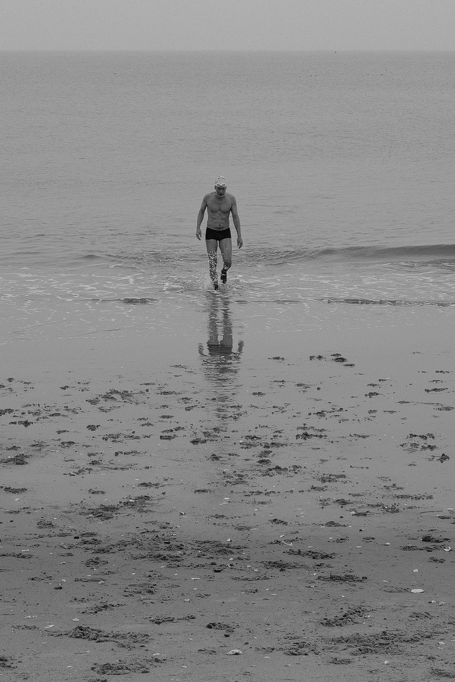 Nageur sortant de l'eau, sa silhouette se refletant sur le sable mouille, Coney Island