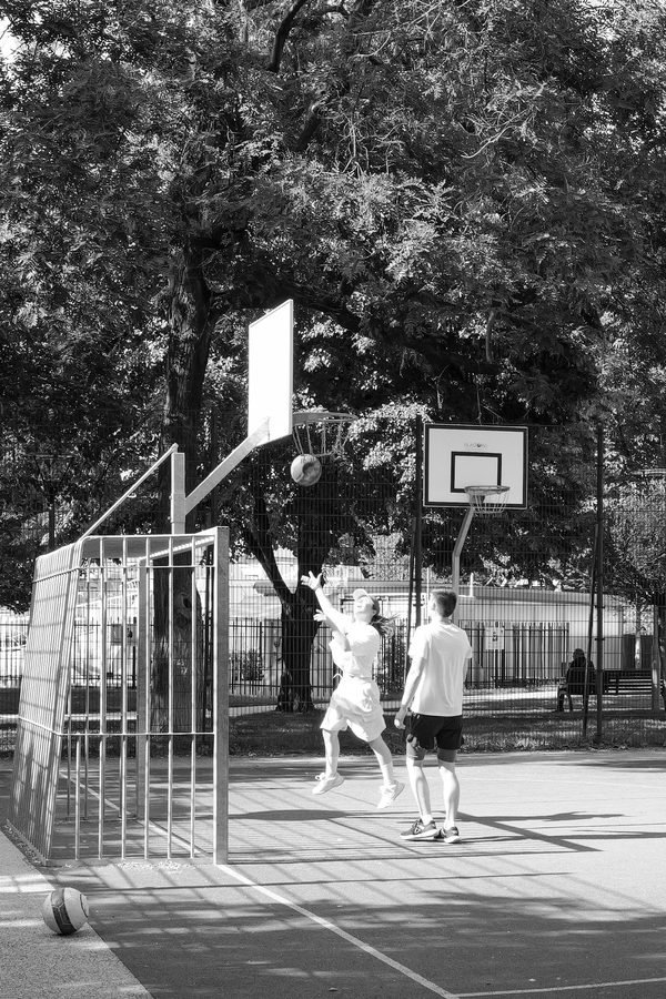 Enfants jouant au basket sur un terrain exterieur en soiree, Budapest