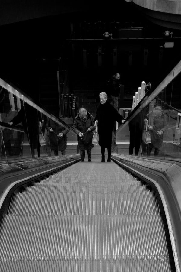 Passants traversant une passerelle pietonne moderne de nuit, Rotterdam
